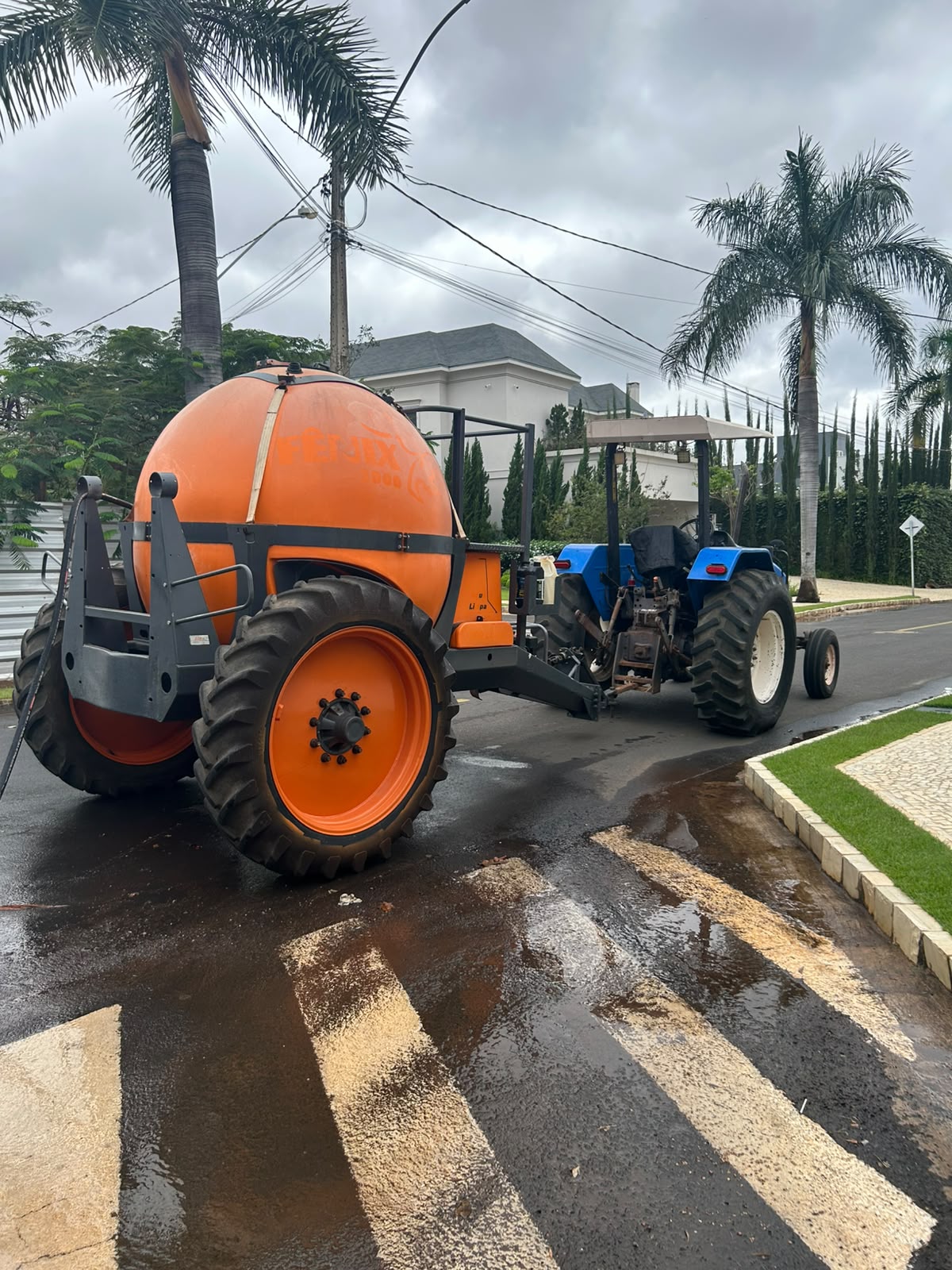 Trator agrícola com tanque de água em operação no Condomínio Paquetá